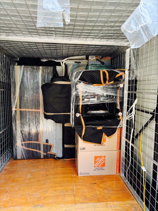 Interior view of a storage unit packed with car floor mats, boxes, and automotive accessories organized on shelves